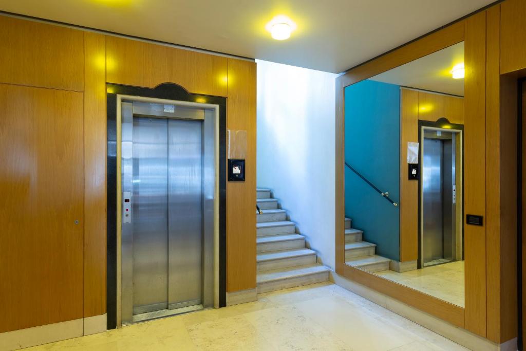 a hallway with elevators and stairs in a building at LAUS app. 1 - ART & DESIGN nel cuore di Bari - VIA DANTE ALIGHIERI in Bari