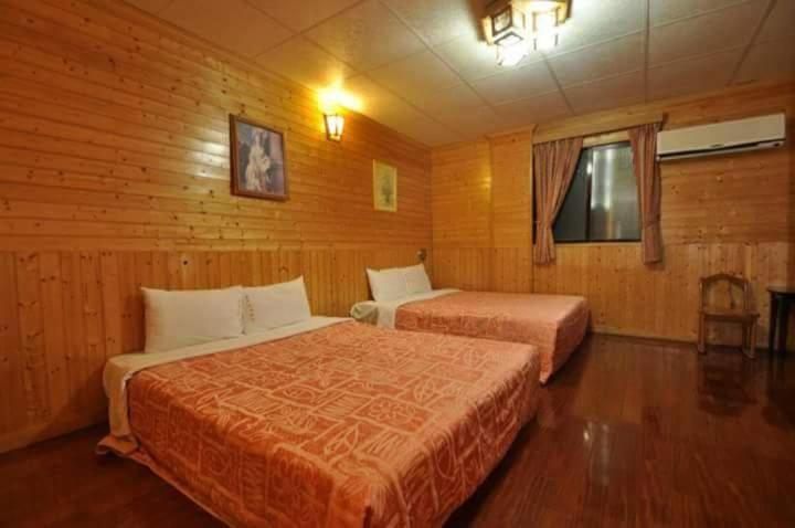 1 dormitorio con 2 camas en una habitación de madera en 四重溪洺泉溫泉旅館, en Checheng