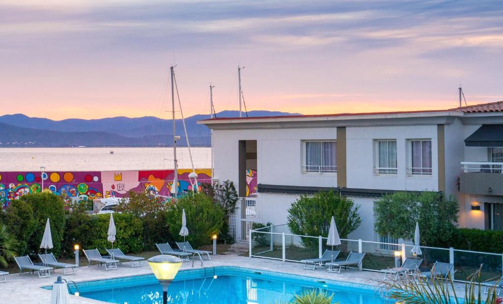 un hôtel avec une piscine devant un immeuble dans l'établissement Duplex à La Marina, à Saint-Raphaël