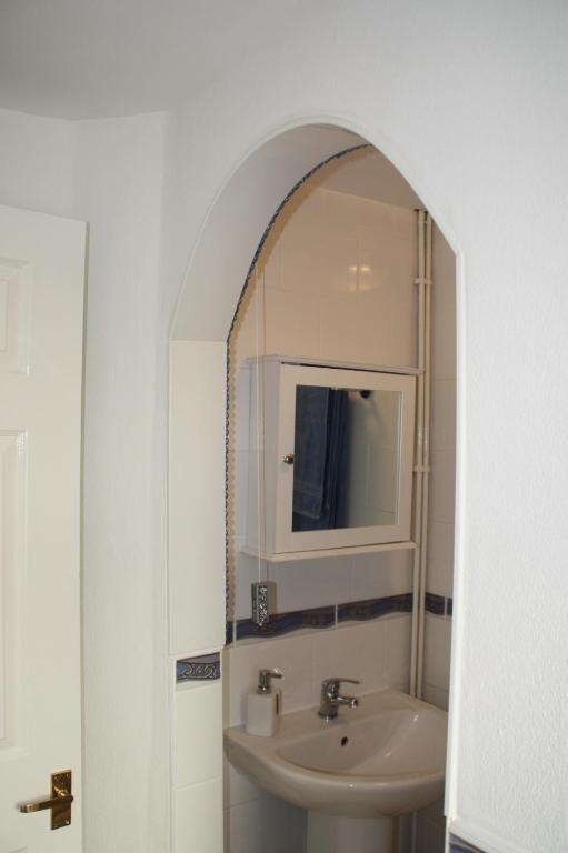 a bathroom with a sink and a mirror at Ortari@70 in Bishopston