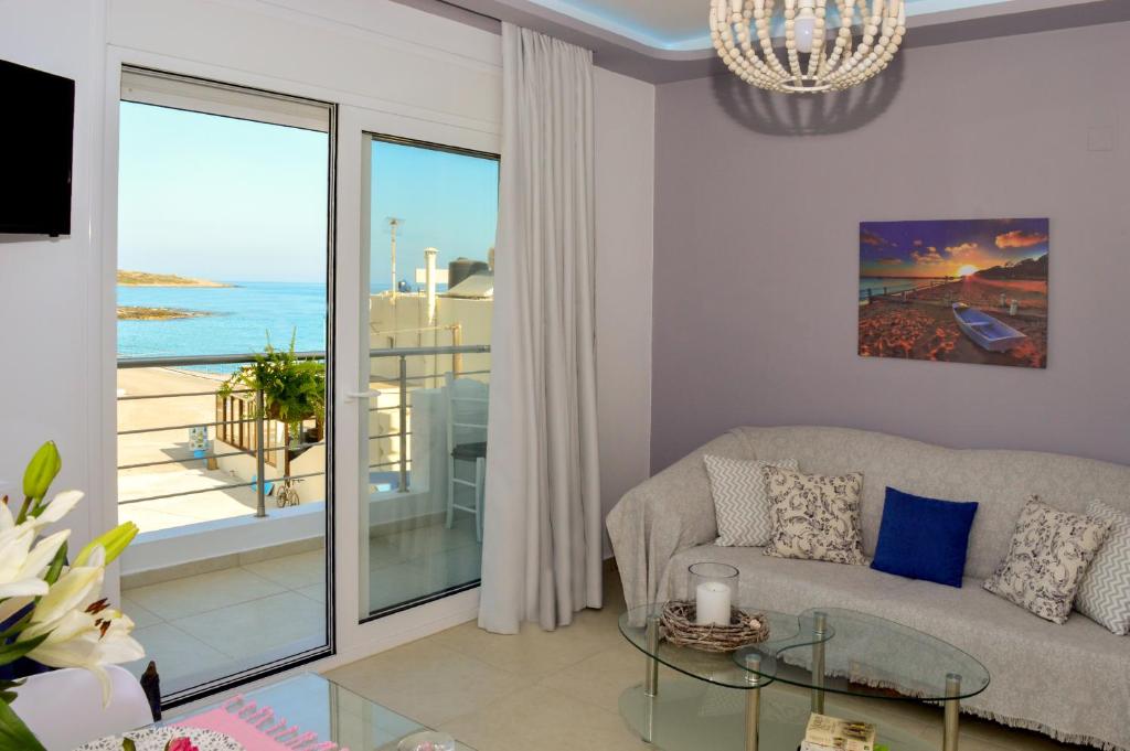 a living room with a couch and a glass table at Meltemi Beach Apartments in Milatos