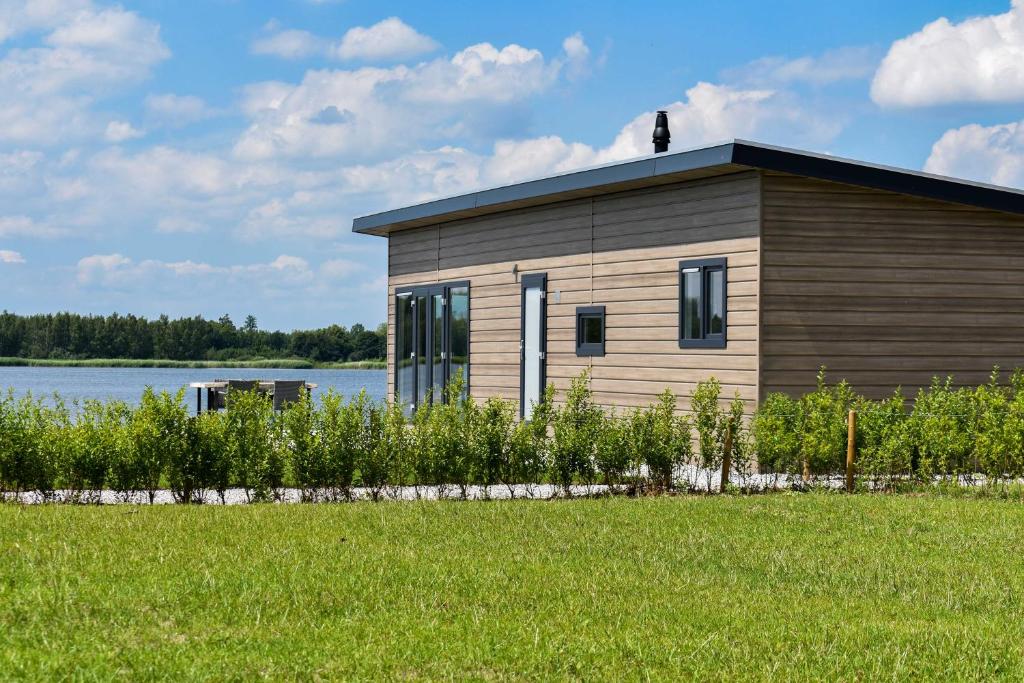 een klein gebouw met een grasveld ervoor bij Strandparc Nulde in Putten