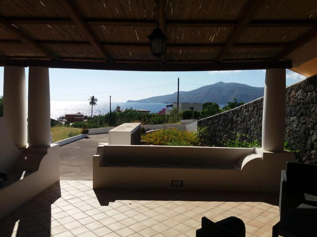 un sofá grande sentado en un patio con vistas al océano en Salina Case Vacanze, en Santa Marina Salina