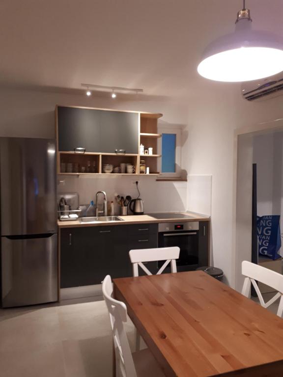 a kitchen with a wooden table and a stainless steel refrigerator at Apartment Adriatic in Makarska