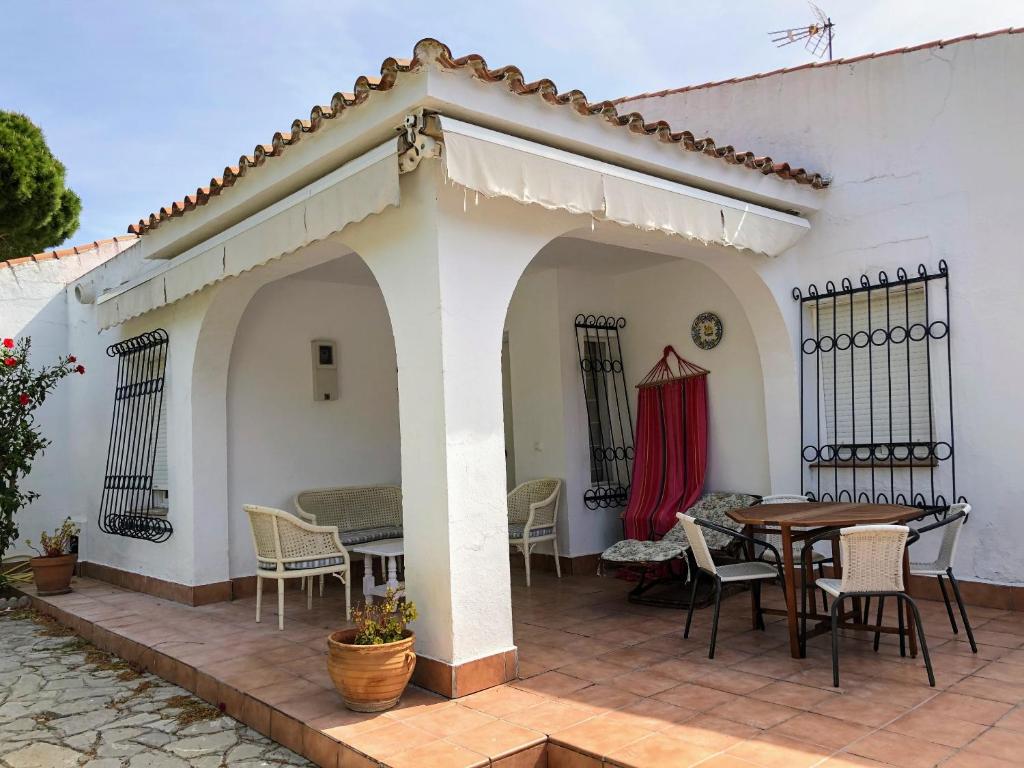 een patio met een tafel en stoelen in een huis bij Chalet La Costa in Chiclana de la Frontera