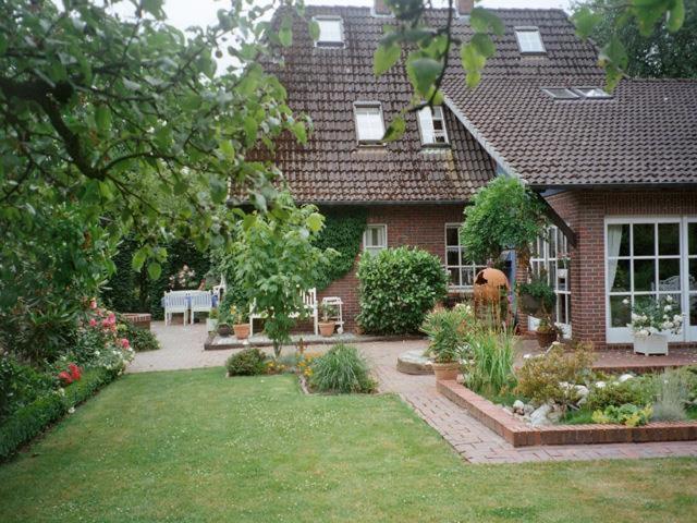 a house with a garden in front of it at Ferienwohnung Landhaus im Grünen in Bad Zwischenahn