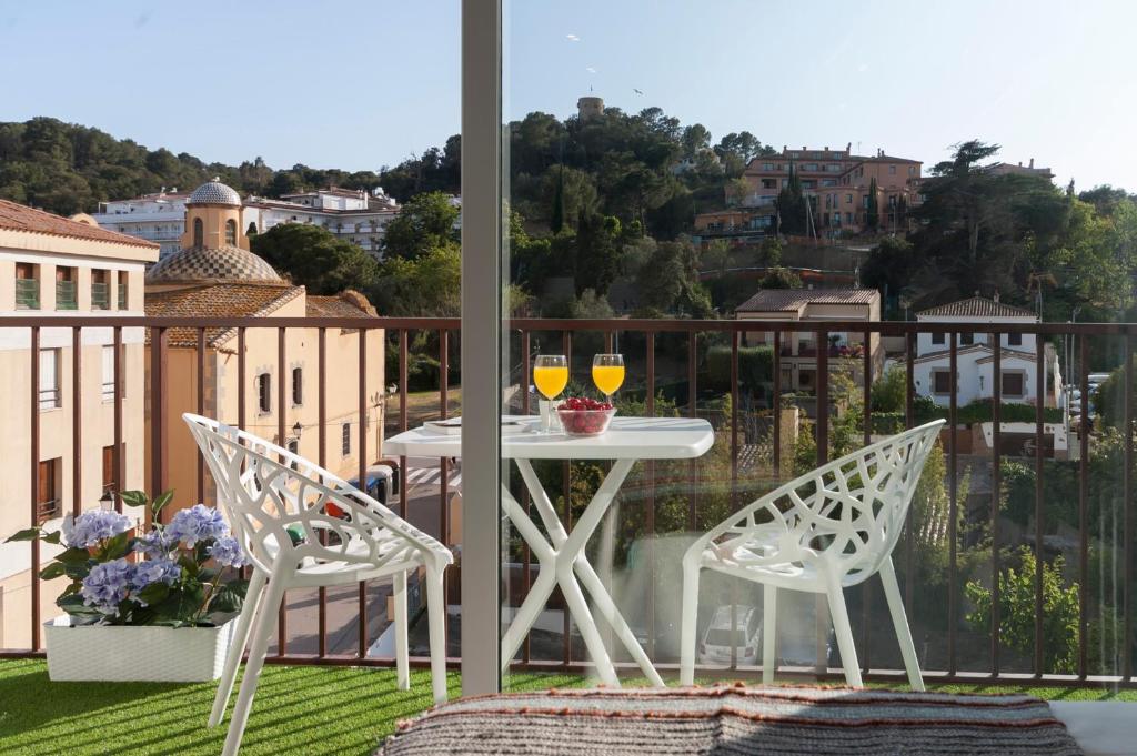 een balkon met een tafel en 2 glazen wijn bij Lets Holidays Studio in Tossa in Tossa de Mar