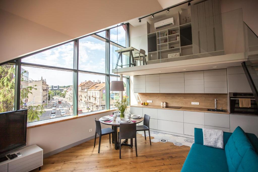 eine Küche und ein Esszimmer mit einem Tisch im Zimmer in der Unterkunft Penthouse in the City Center in Vilnius