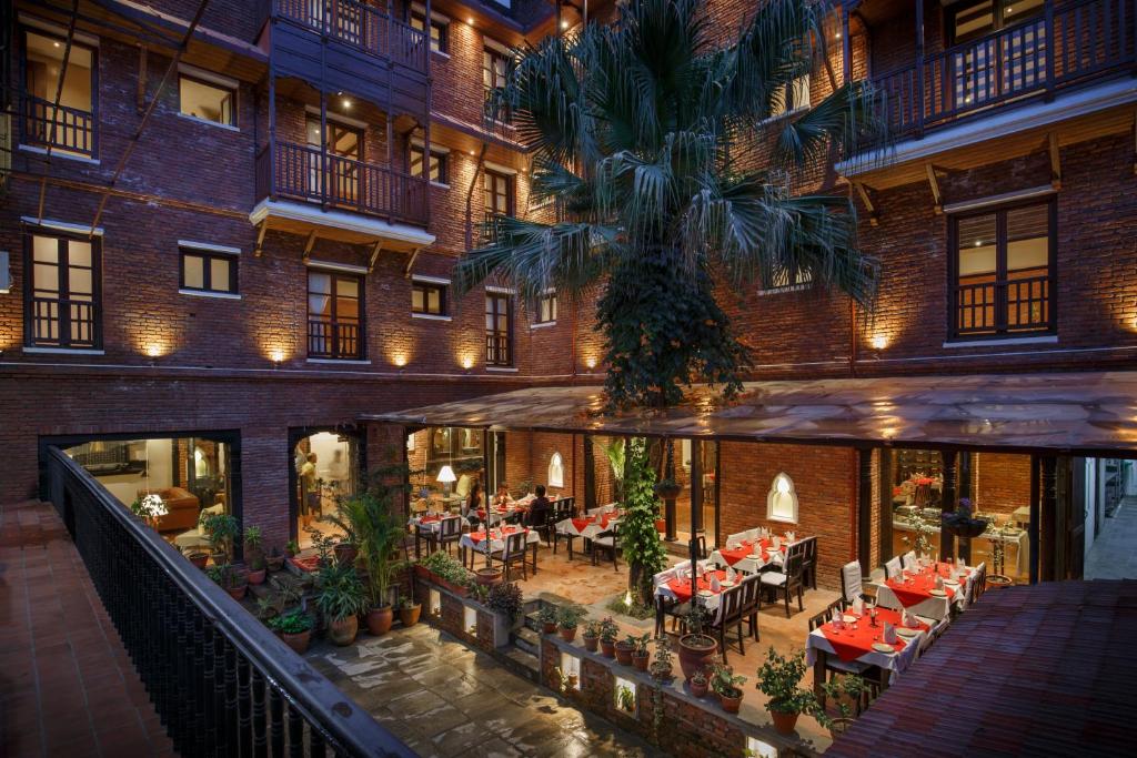 an apartment building with a courtyard with tables and chairs at Hotel Thamel House in Kathmandu