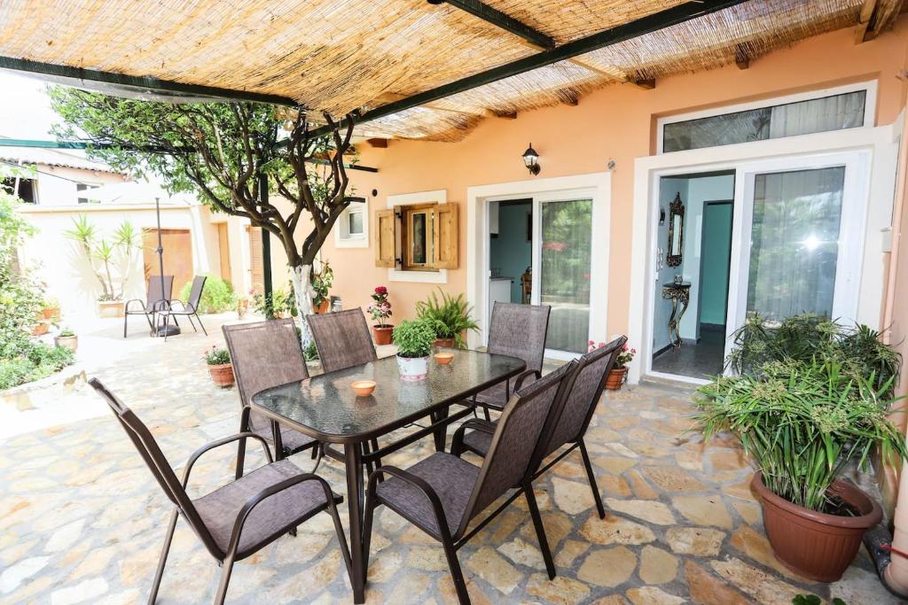 an outdoor patio with a table and chairs at Garden House Kastellani in Kastellánoi