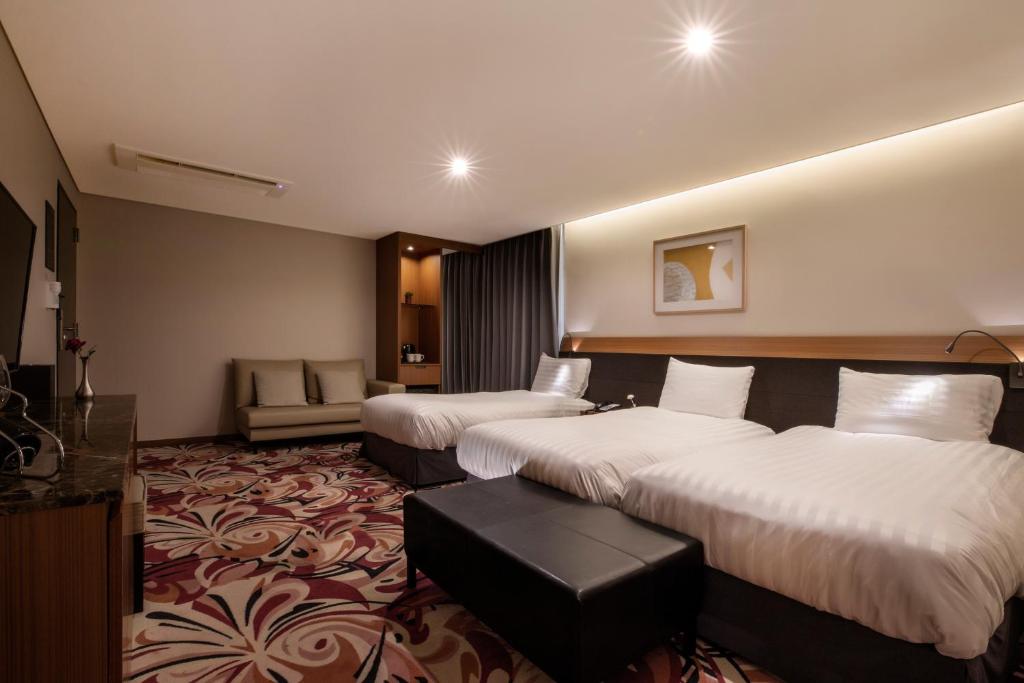 Postel nebo postele na pokoji v ubytování Shin Shin Hotel Jeju Airport
