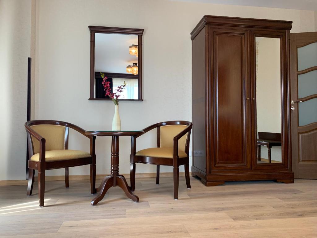 a dining room table with two chairs and a mirror at Pensiunea Junior in Cluj-Napoca