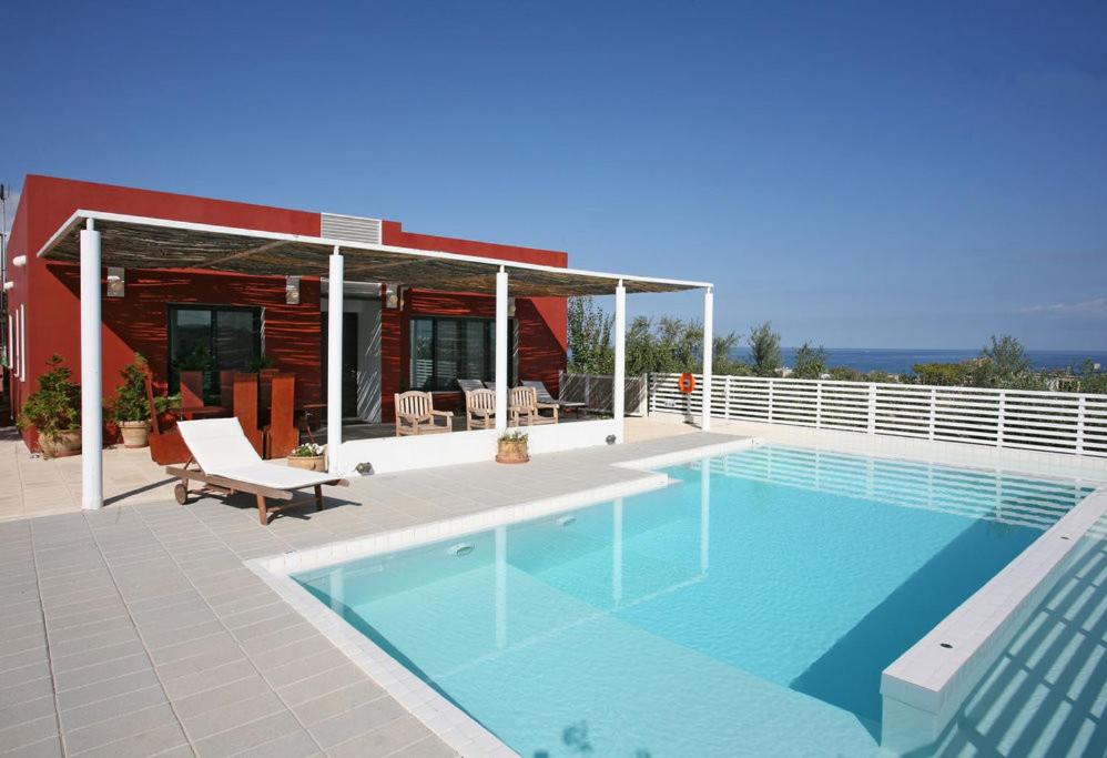 a swimming pool in front of a house at Villa Bamboo in Maleme