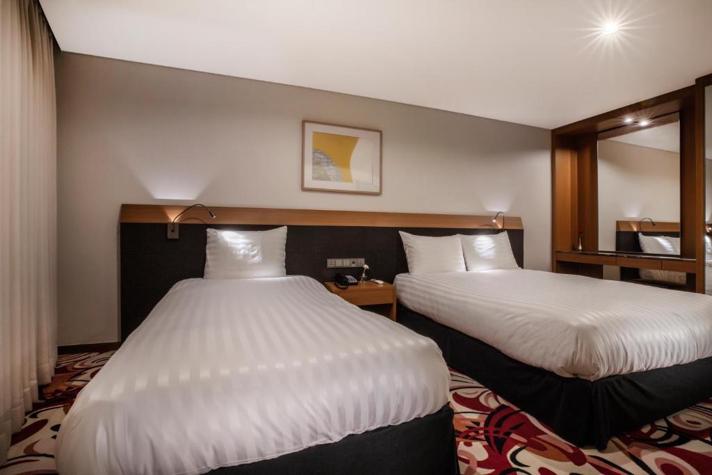 Postel nebo postele na pokoji v ubytování Shin Shin Hotel Jeju Airport