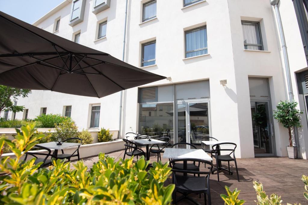 a patio with tables and chairs in front of a building at Zenitude Hôtel-Résidences Narbonne Centre in Narbonne