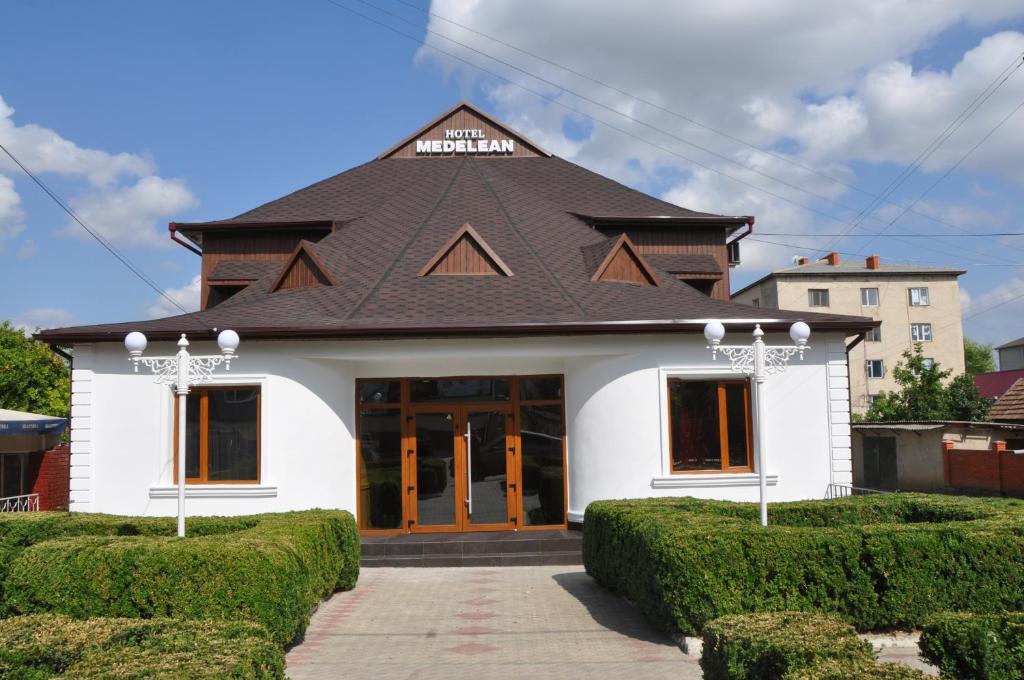 un gran edificio blanco con techo negro en MEDELEAN HOTEL, en Komrat