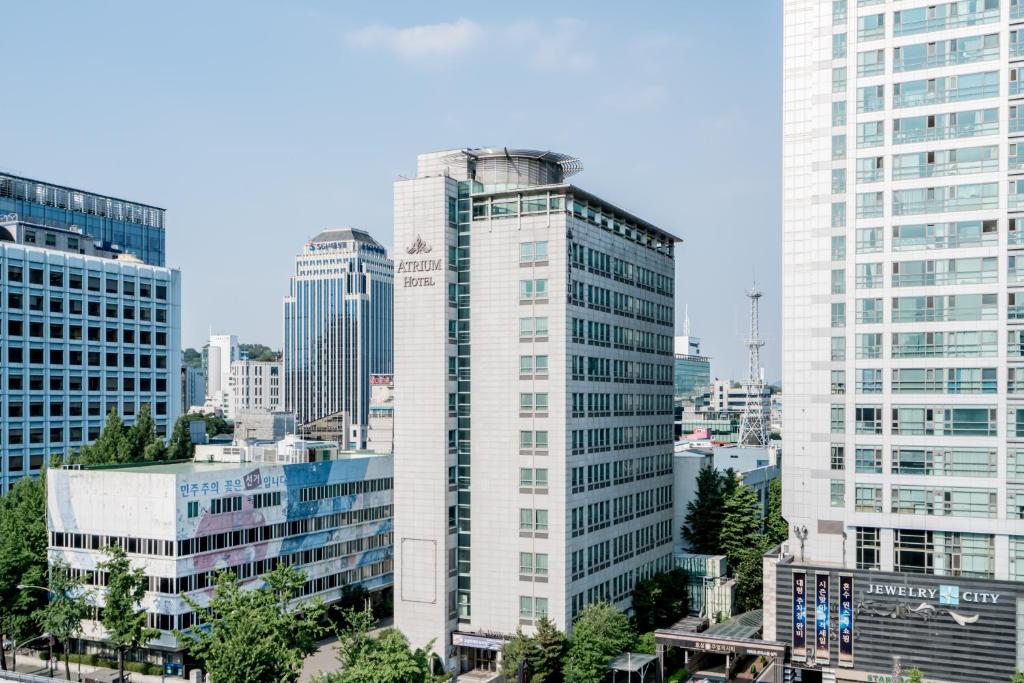 un edificio alto y blanco en medio de una ciudad en Hotel Atrium Jongno, en Seúl