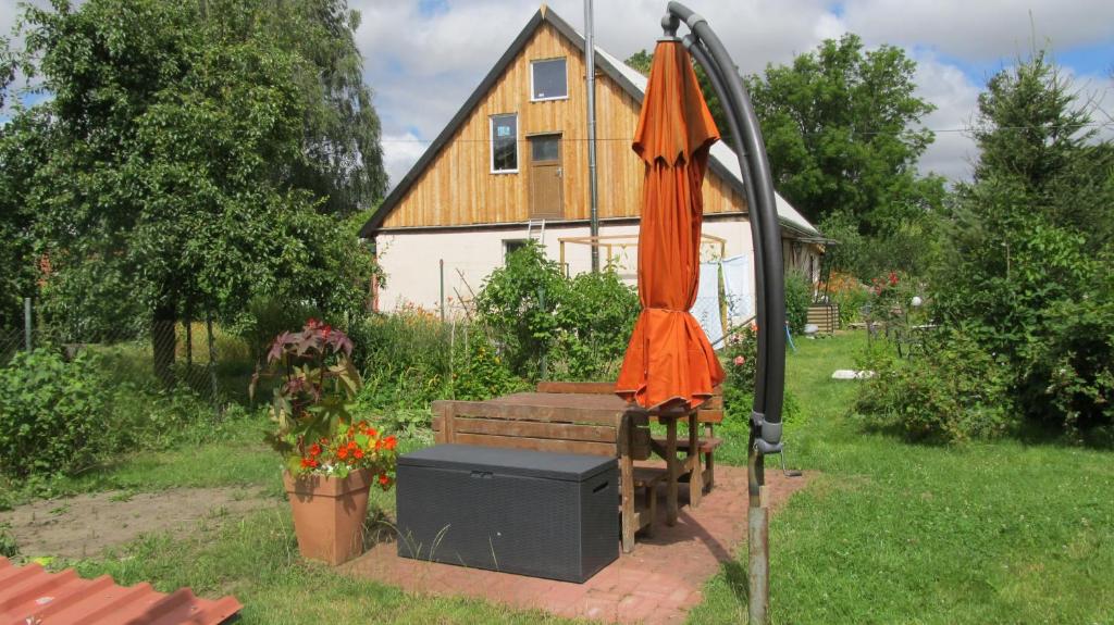 an orange umbrella sitting in a yard next to a house at Idylle in ländlicher Umgebung in Weitenhagen