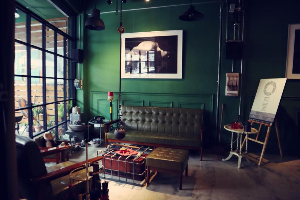 Travel Charger Hostel في مدينة هوالين: غرفة خضراء مع أريكة وطاولة