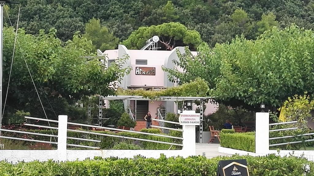 a white house with a man standing in front of it at Agyra Studios in Vasilika