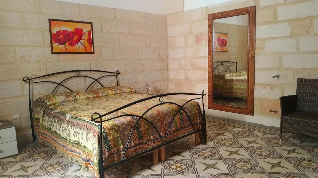 une chambre avec un lit et un miroir dans l'établissement La terrazza sul castello, à Palmariggi