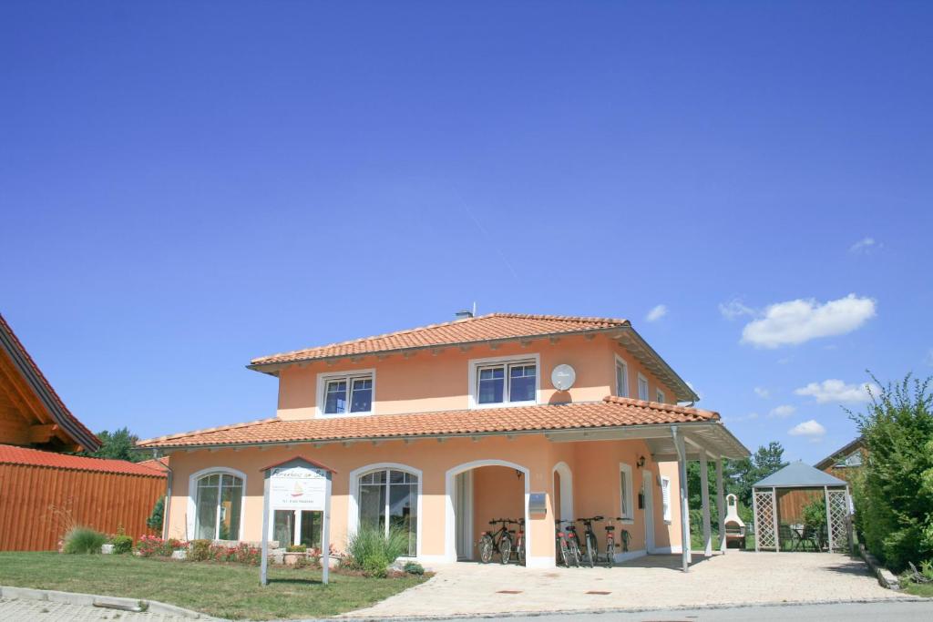 a large orange house with a roof at Ferienvilla am Brückelsee in Wackersdorf