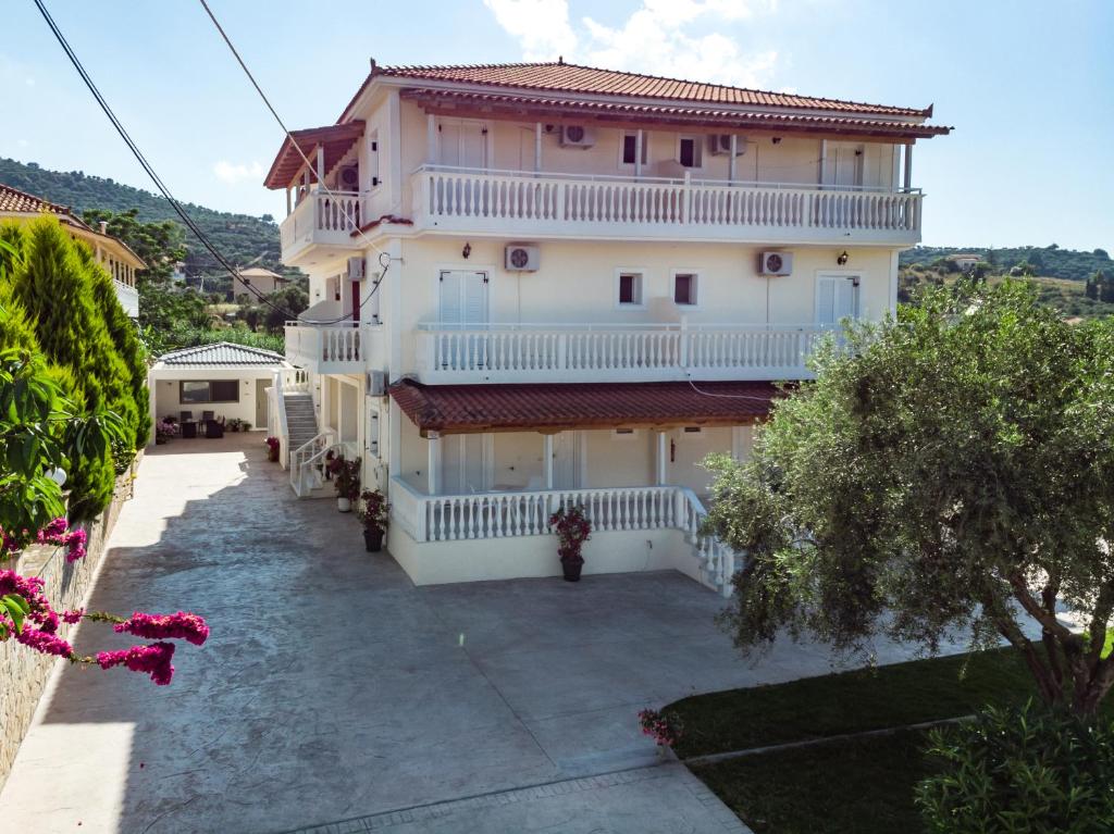 a large white building with balconies and a yard at Villa Georgia in Argassi