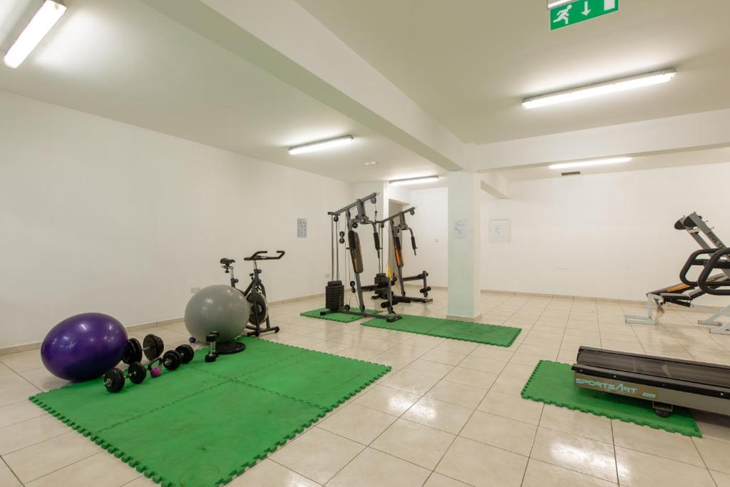 a gym with exercise equipment and green mats at Oceania Bay Village in Pyla