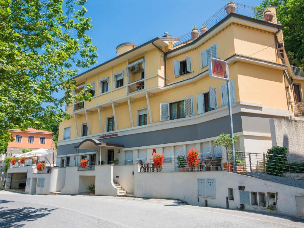 un edificio giallo con fiori sui balconi di Apartment Relais-3 by Interhome a San Baronto