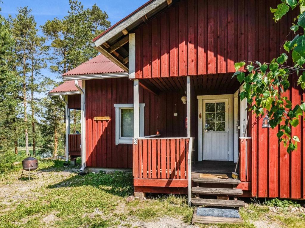ein rotes Haus mit einer weißen Tür und einer Veranda in der Unterkunft Holiday Home Kalatiira 3 by Interhome in Strandby