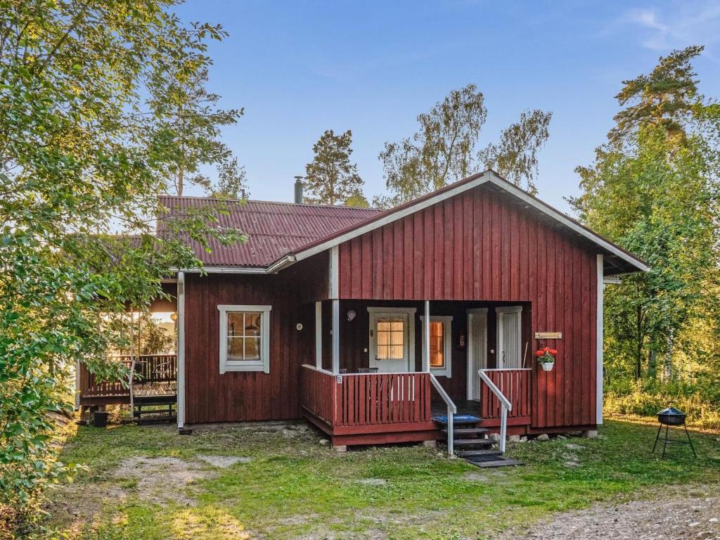 uma pequena casa vermelha com um alpendre frontal em Holiday Home Isokoskelo 5 by Interhome em Strandby