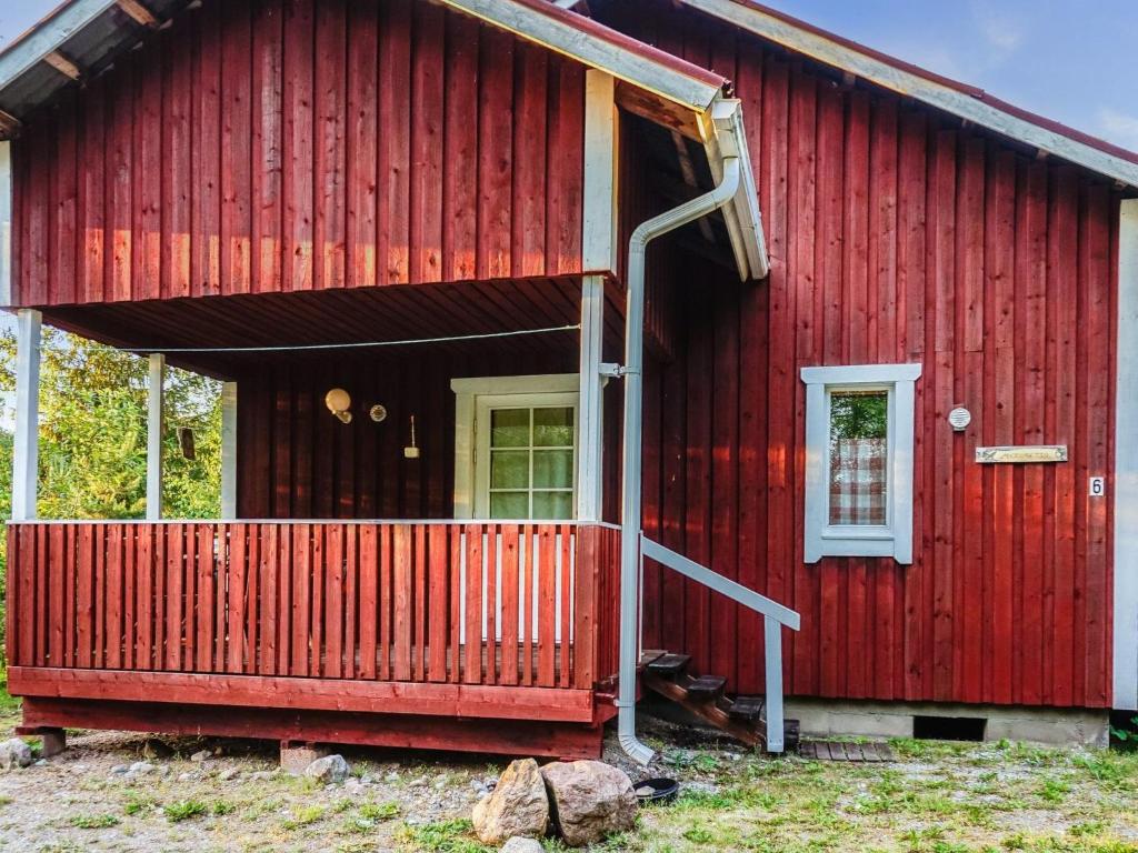 a red house with a front porch and a door at Holiday Home Merimetso 6 by Interhome in Strandby