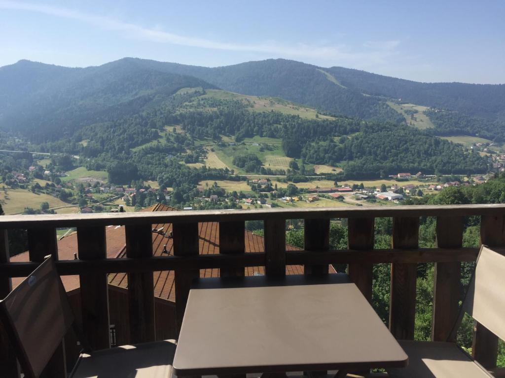 a table on a balcony with a view of mountains at Charmant T3 Bussang, Vosges, vue imprenable in Bussang
