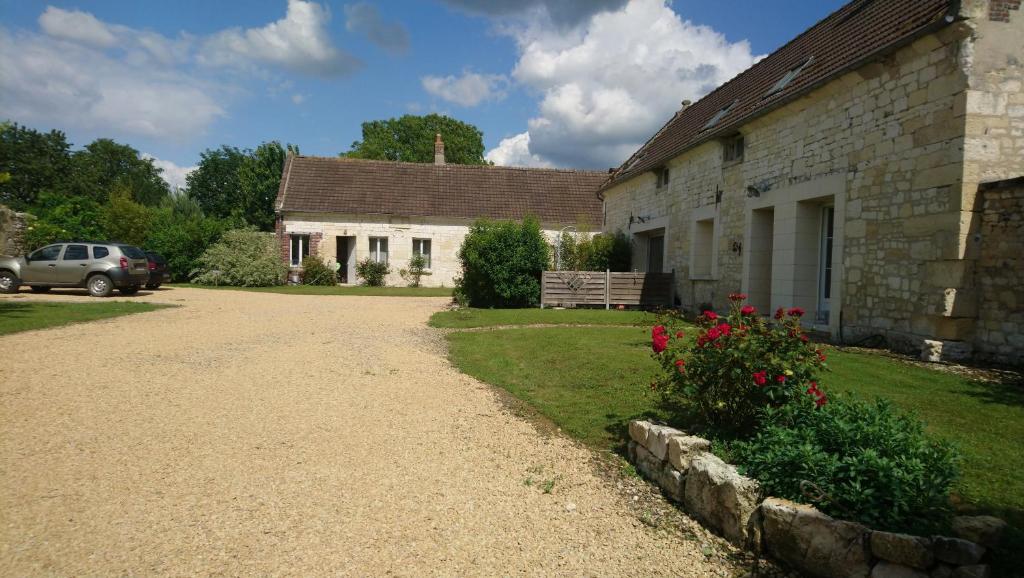 ein Haus mit Kieseinfahrt neben einem Gebäude in der Unterkunft Chambres d'hôtes - La rose des champs in Lachelle