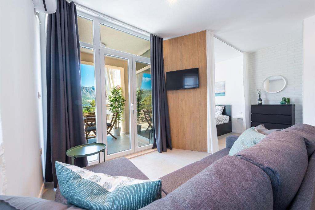 sala de estar con sofá y ventana grande en Apartment Diverti en Dubrovnik