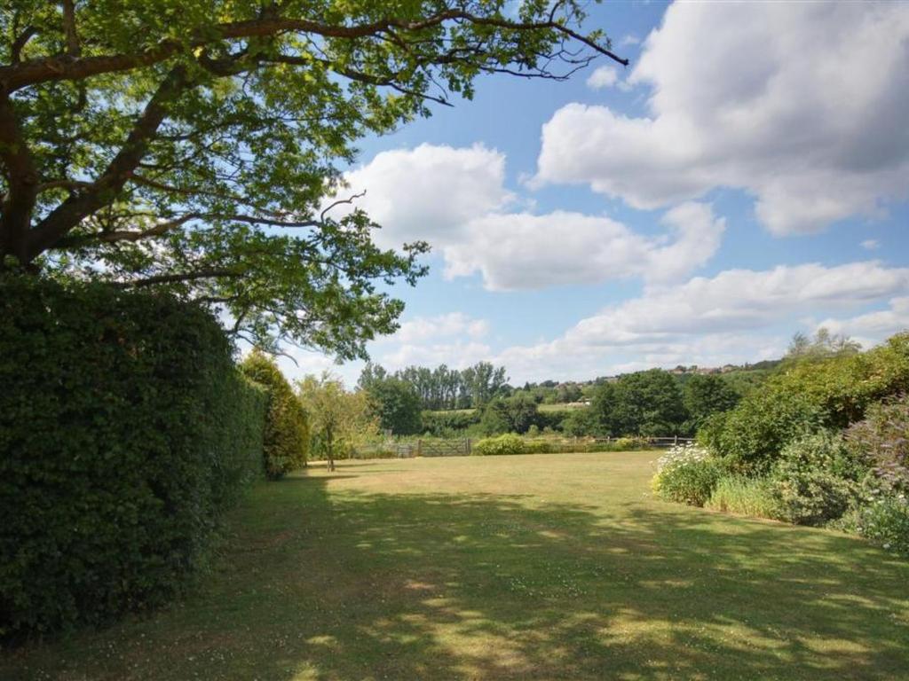 a large grass field with a tree in the foreground at Holiday Home Baley by Interhome in Goudhurst