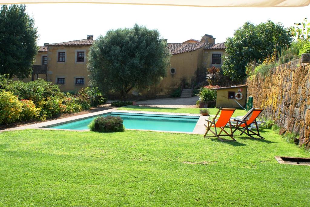a yard with two chairs and a swimming pool at Quinta Da Agra in Ponte de Lima