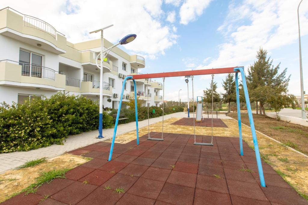 an empty playground in front of a building at Oceania Bay Village in Pyla