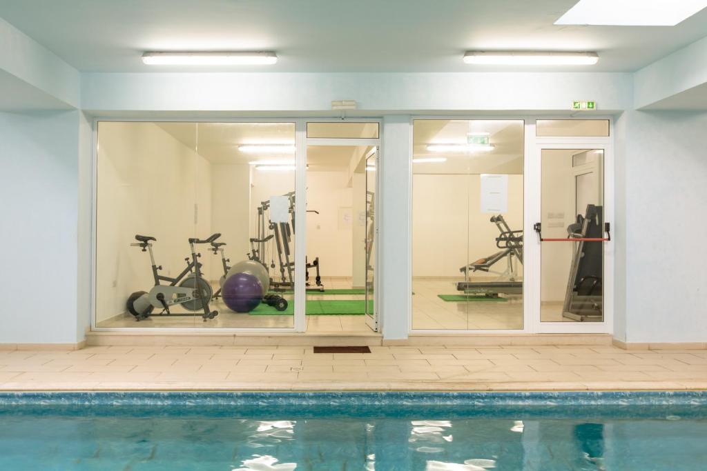 a gym with a swimming pool and exercise equipment at Oceania Bay Village in Pyla