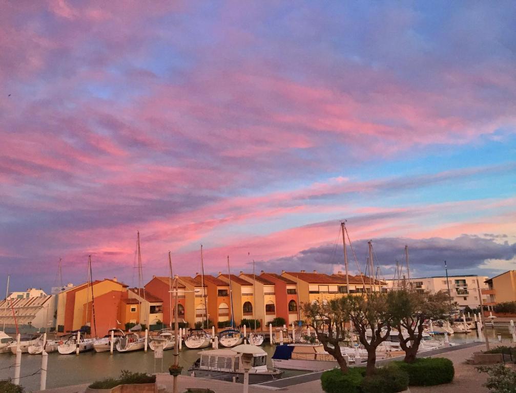 un groupe de bateaux amarrés dans une marina au coucher du soleil dans l'établissement Appartement Carnon Plage, à Carnon-Plage