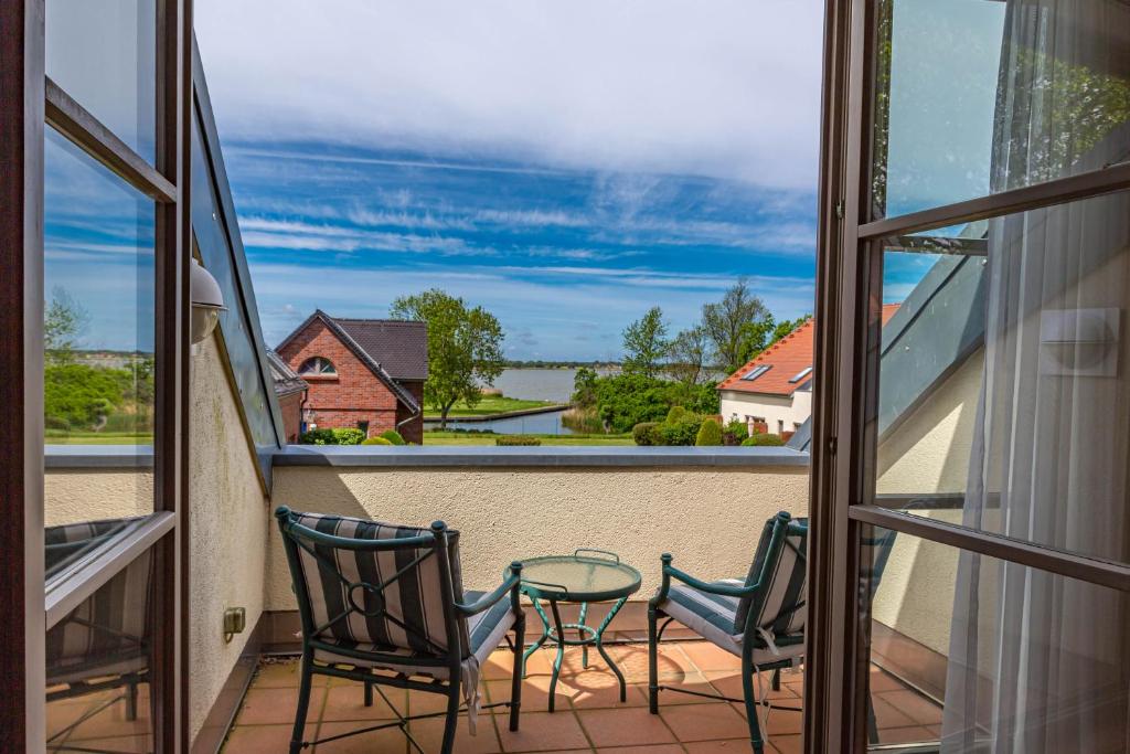 a balcony with chairs and a table and a view of the water at Ferienwohnung Wasserblick in Dewichow