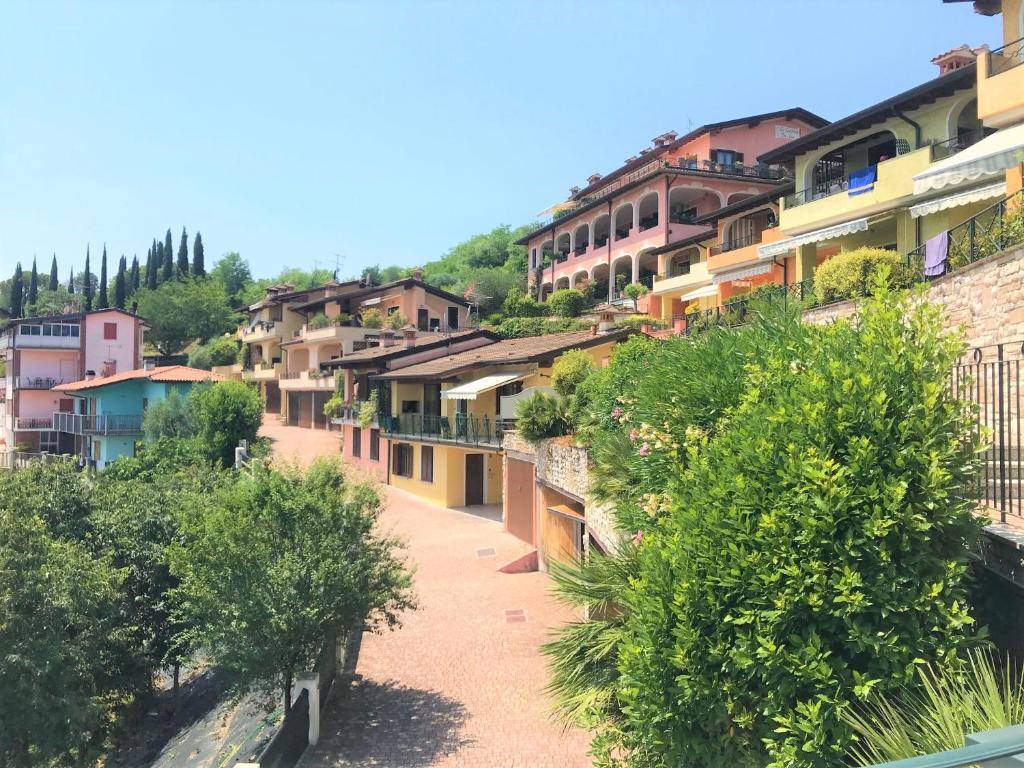szereg domów na wzgórzu z drzewami w obiekcie Alice's Nest-Lake View House w mieście Padenghe sul Garda