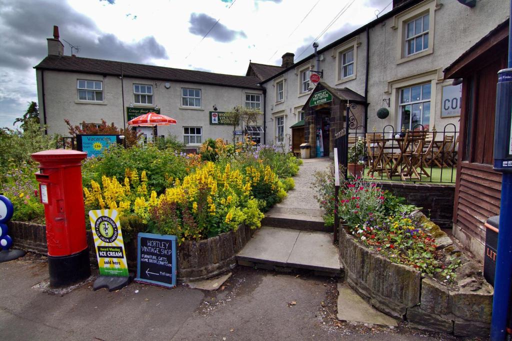 a garden with flowers in front of a building at Wortley Cottage Guest House in Wortley