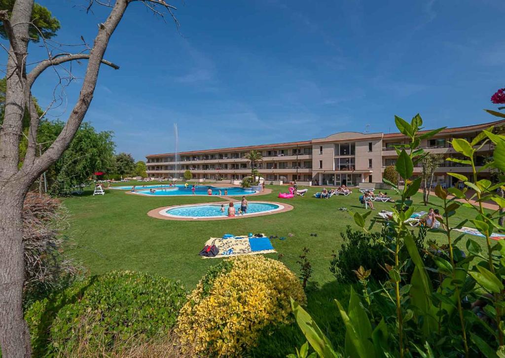 a building with a large yard with a swimming pool at Aparthotel Golf Beach in Pals