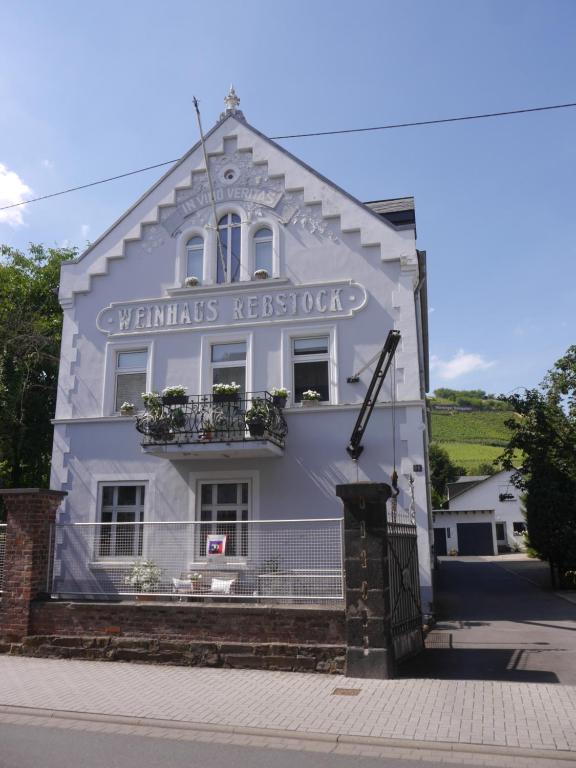 ein weißes Gebäude mit einem Schild an der Seite in der Unterkunft Altes Weingut Weinhaus Rebstock in Winningen