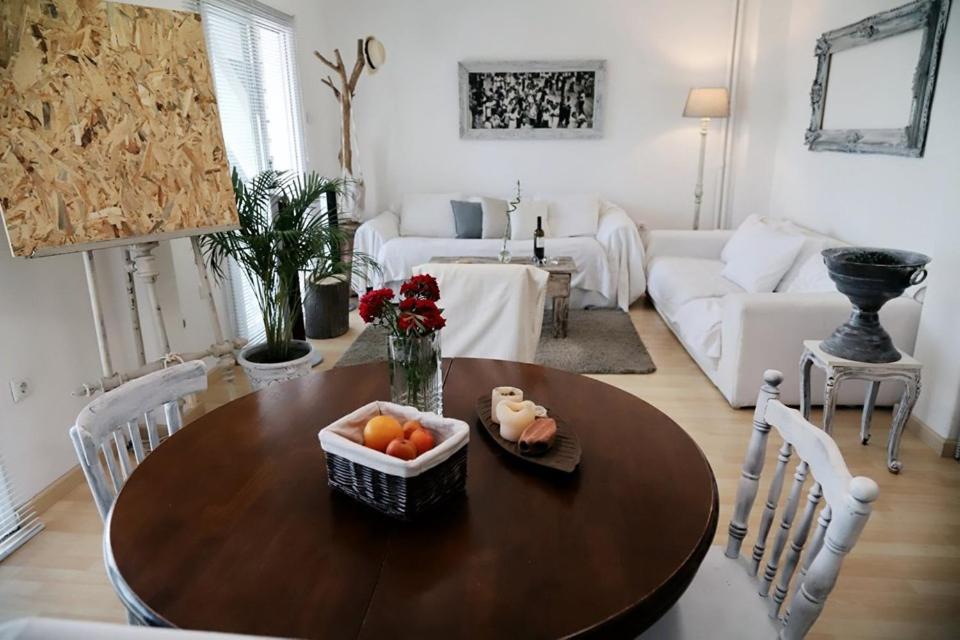uma sala de estar com uma mesa com uma taça de fruta em Sailing House on the beach 16 persons em Atenas