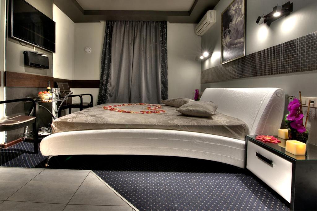 a bedroom with a white bed and a table at Alex Hotel on Dybenko in Saint Petersburg