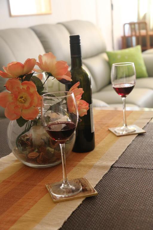 una mesa con dos copas de vino y un jarrón de flores en Apartment Stan Zadar, en Zadar