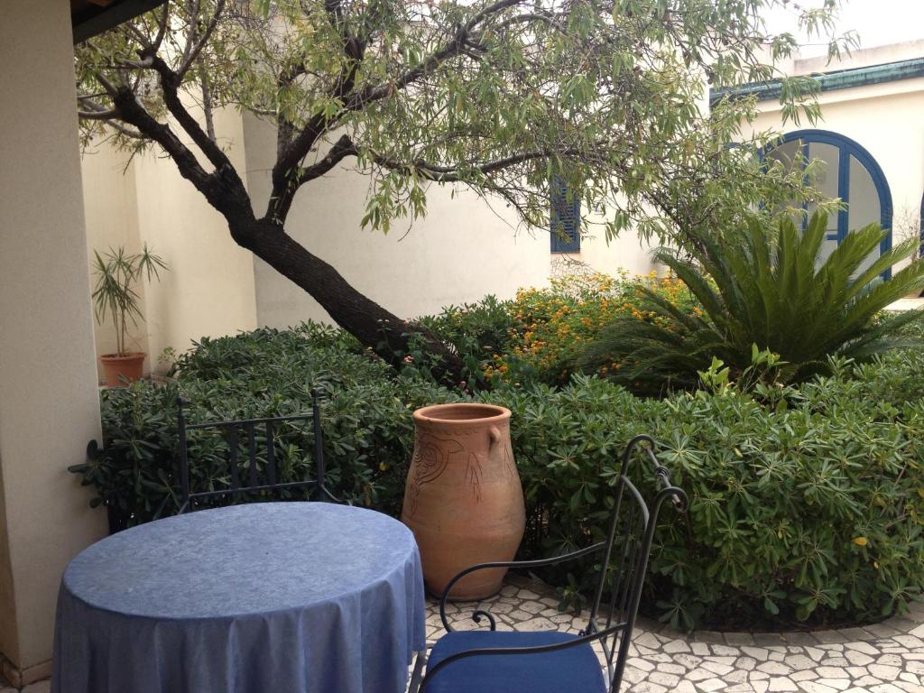 a table and a vase sitting next to a tree at Hotel Aura in Vulcano
