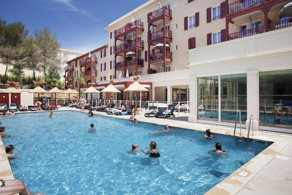 un groupe de personnes dans une piscine d'un hôtel dans l'établissement Résidence Prestige Odalys Les Canissons, à Cavalaire-sur-Mer